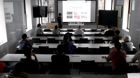 Classroom of people watching someone present a slideshow